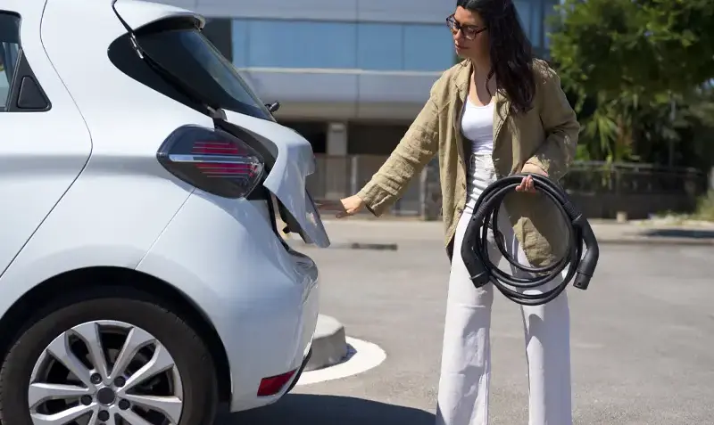 woman charging electric car